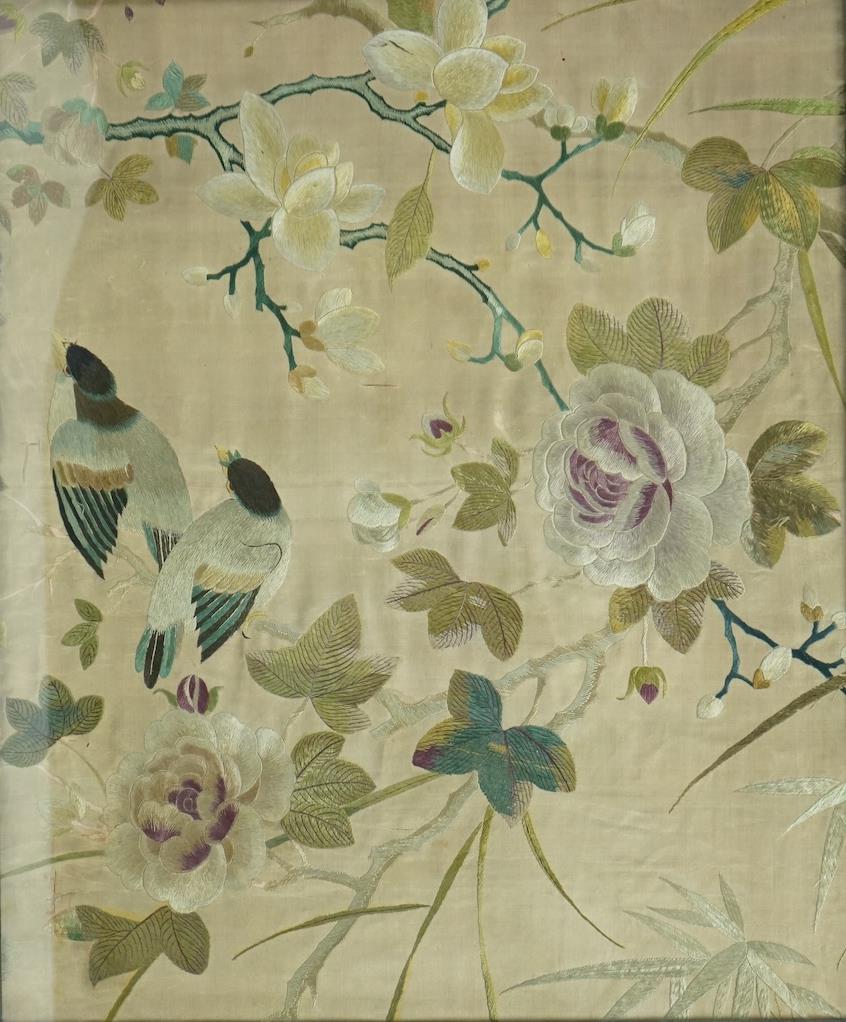 A pair of framed 19th century Chinese silk embroideries of exotic birds amongst entwined flowering branches, embroidered on a beige silk back ground, possibly cut from a larger embroidery. 47cm x 57cm., Condition - one f